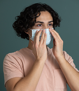 Man putting on medical face mask.